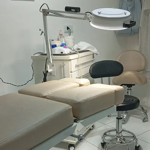 Sala de atendimento de podologia da Lara Matiasi, com maca e equipamentos higienizados